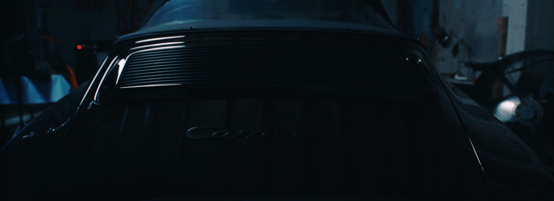 Detailbeeld van de motorklep en carrosserielijnen van een klassieke Porsche 911