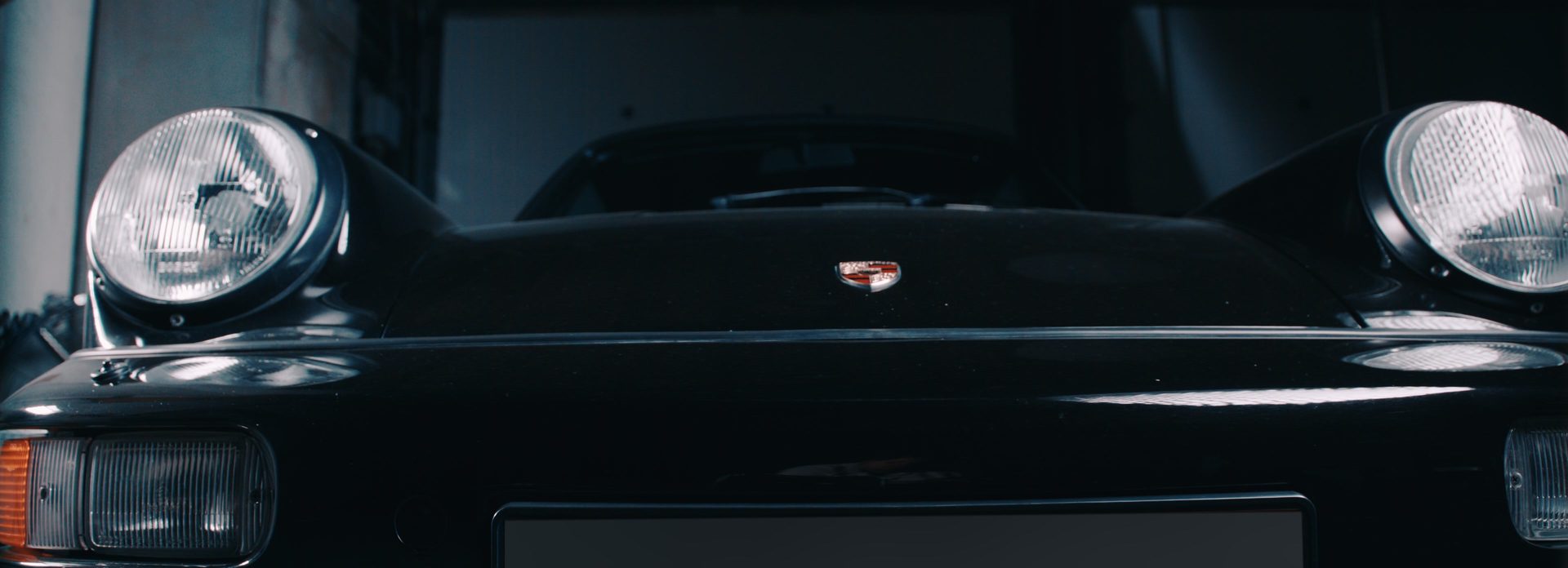 Frontaal detailbeeld van een klassieke Porsche 911 in donkere belichting