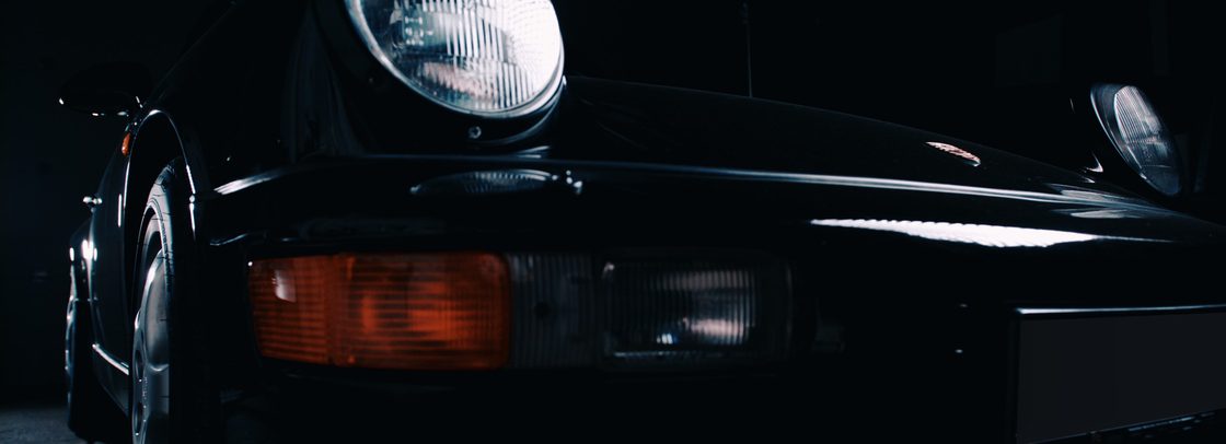 Schuine voorzijde van een klassieke Porsche 911 in donkere belichting