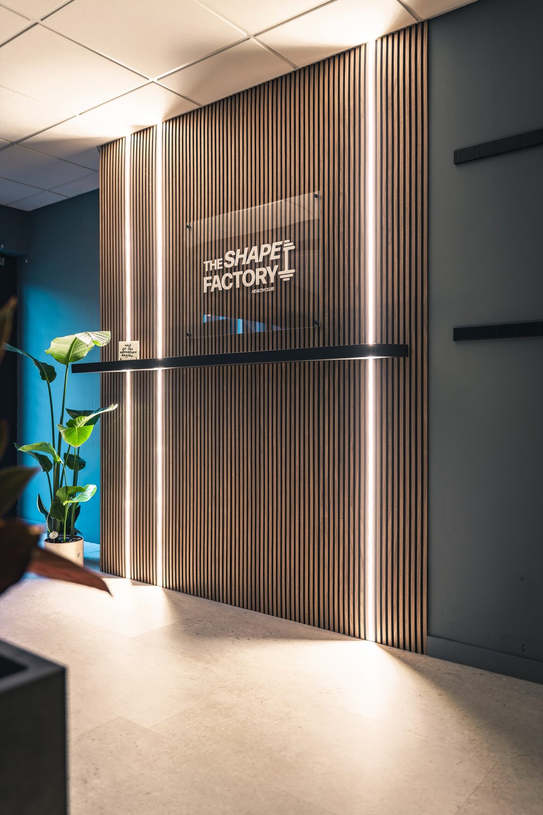 Houten logowand bij de ingang van The Shape Factory