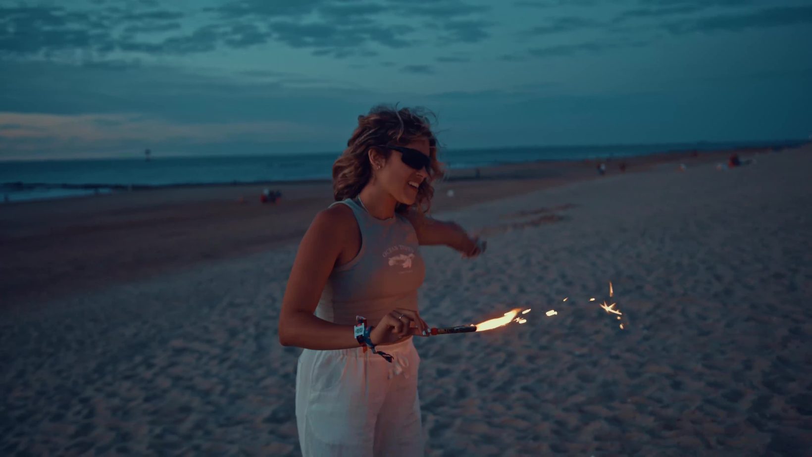WeDream screengrab van een vrouw met vuurwerk op het strand uit de showreel